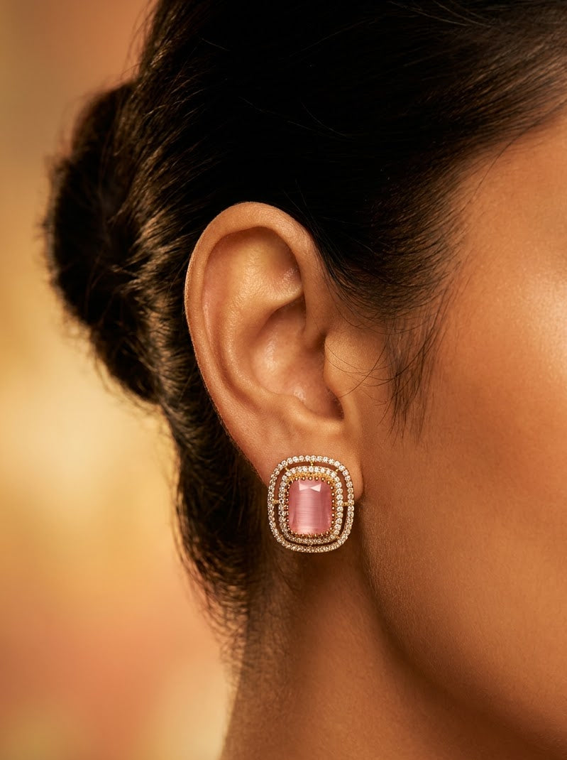 Elegant pink gemstone earrings with sparkling accents and a luxurious gold-tone finish.